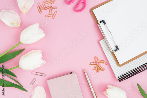 Composition with white flowers, clipboard, clips, notebook and scissors on pink background. Blogger concept. Flat lay, top view.