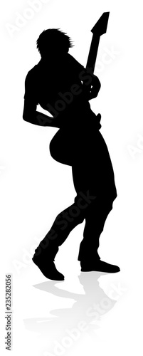 A guitarist musician in detailed silhouette playing his guitar musical instrument.