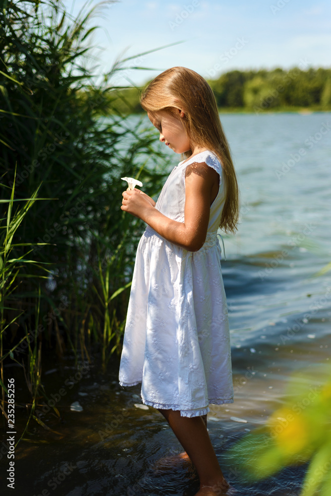 pensive romantic little girl in white dress near river pensive romantic little girl in white dress near river