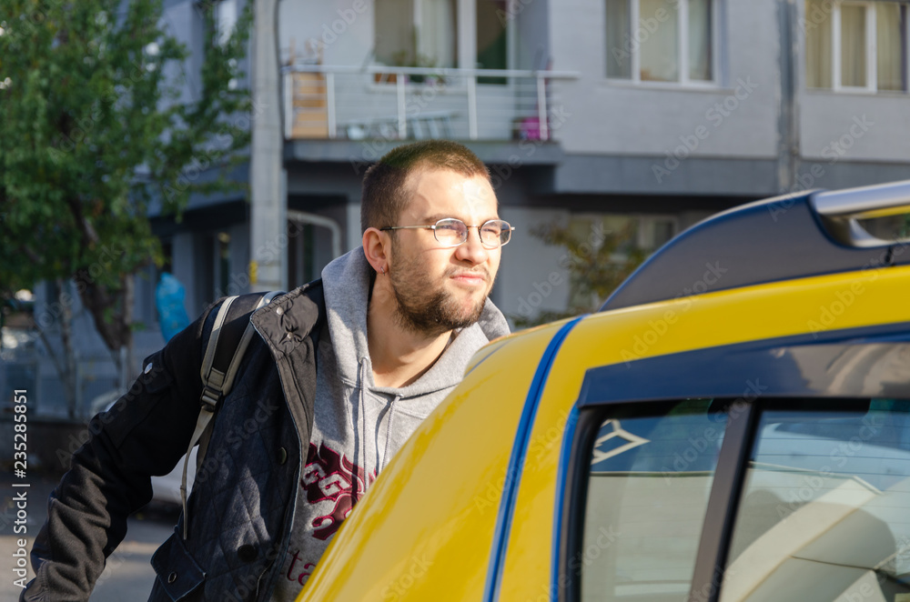 A handsome young man getting in to a taxi A handsome young man getting in to a taxi