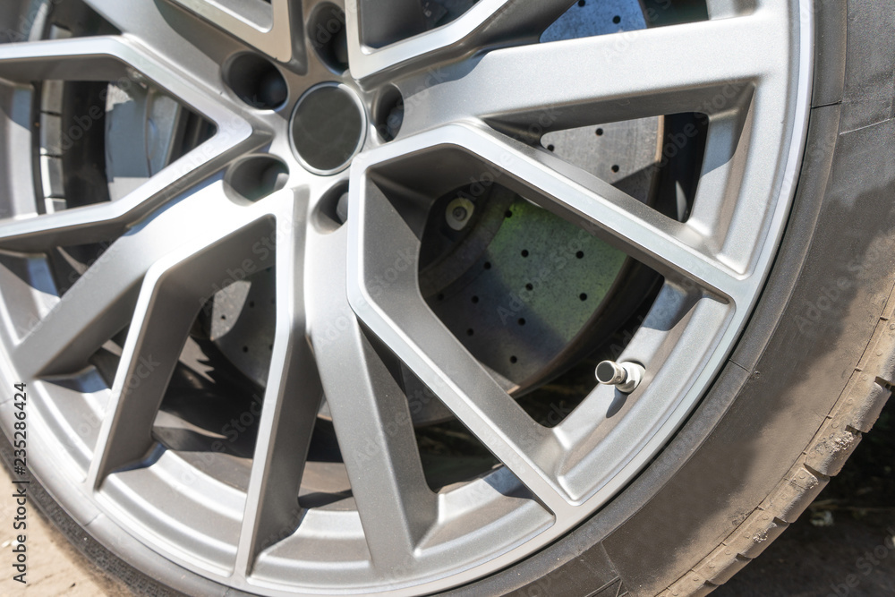 Super car disc brake. Car wheels. steel alloy car disks background template for design work. Car alloy wheel. Close-up shot of a car's brake disc.
