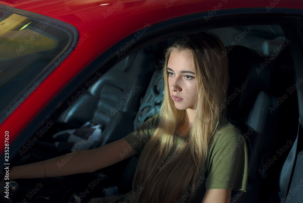 pretty young girl driving a red sports car