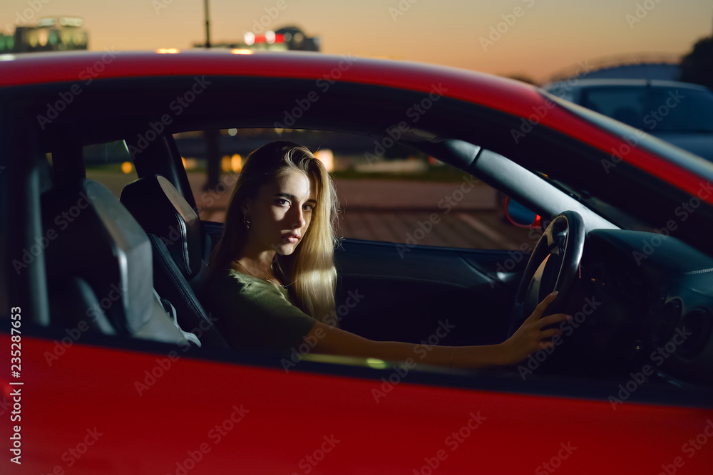 pretty young girl sits behind the wheel