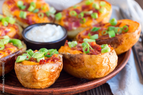 Canvas Print Baked loaded potato skins with cheddar cheese and bacon, garnished with scallion