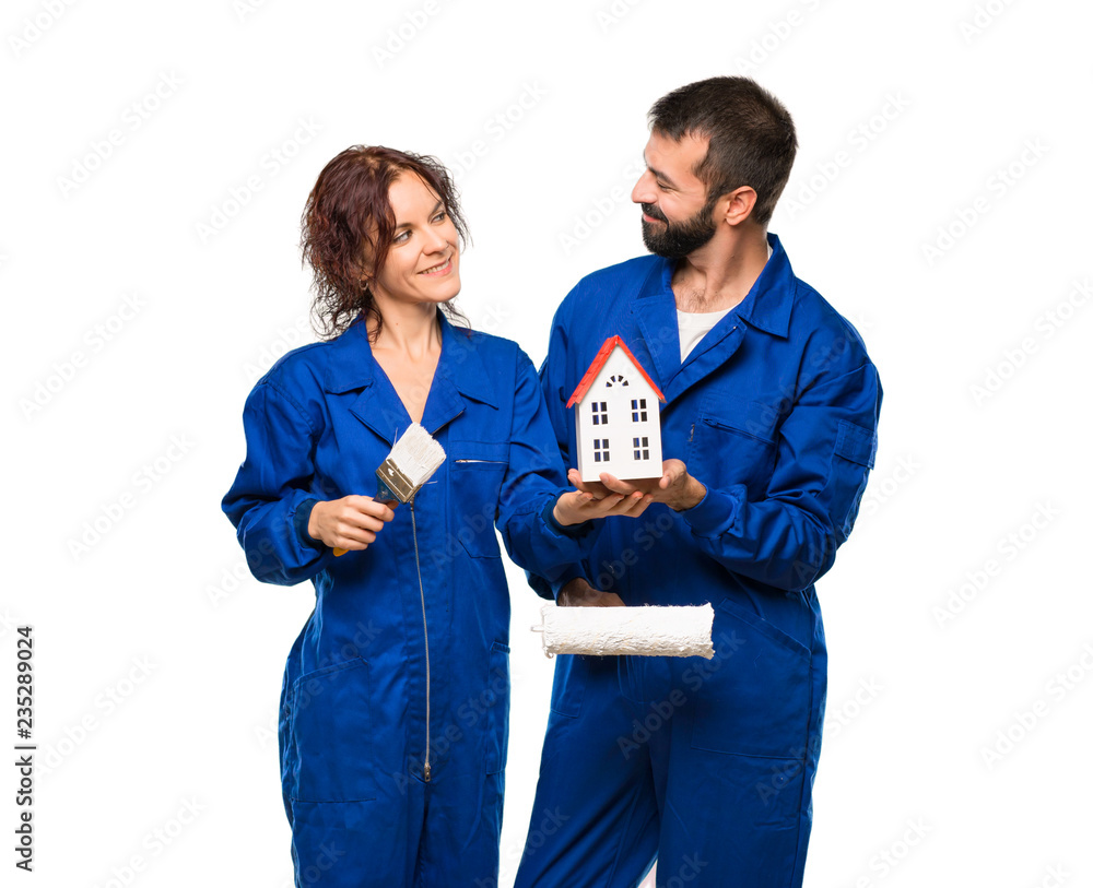 Painters holding a little house on isolated white background Painters holding a little house on isolated white background