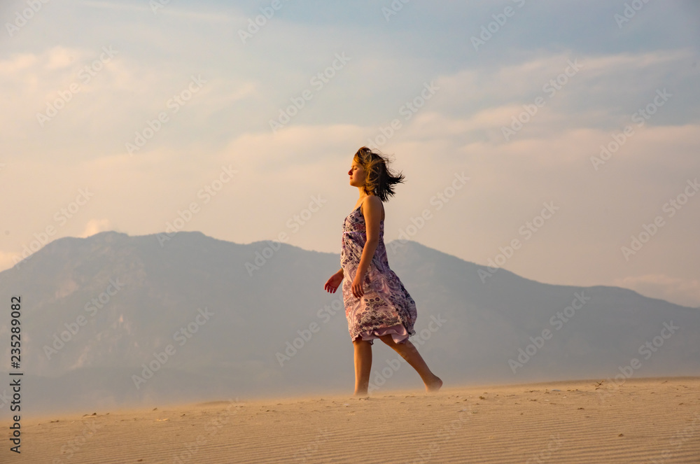 Girl walks on sand desert