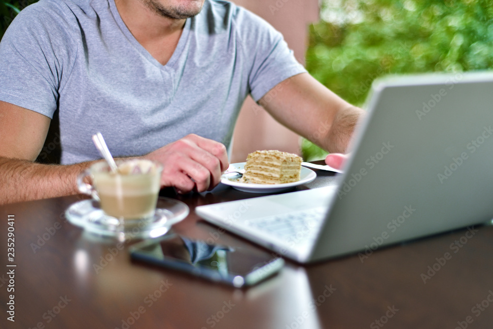 Young guy freelancer working on laptop in cafe Young guy freelancer working on laptop in cafe