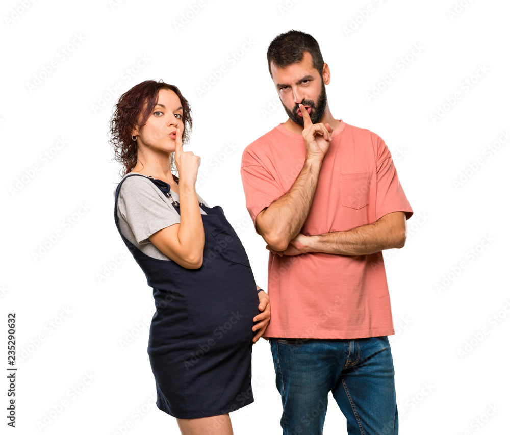 Couple with pregnant woman showing a sign of closing mouth and silence gesture on isolated white background Couple with pregnant woman showing a sign of closing mouth and silence gesture on isolated white background