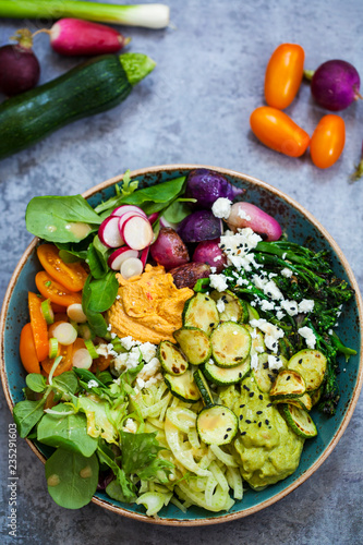 Buddha bowl with mixed roast and fresh vegetables, hummus and miso dressing