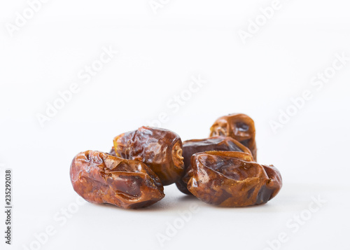 Dried halawi dates on a white photo