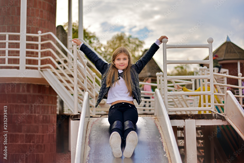 little girl riding down hill on the playground little girl riding down hill on the playground
