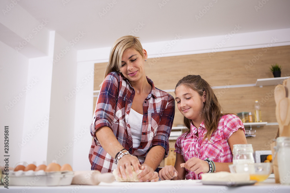 Little girl learning from her mother how to cook. Growing up. Little girl learning from her mother how to cook. Growing up.