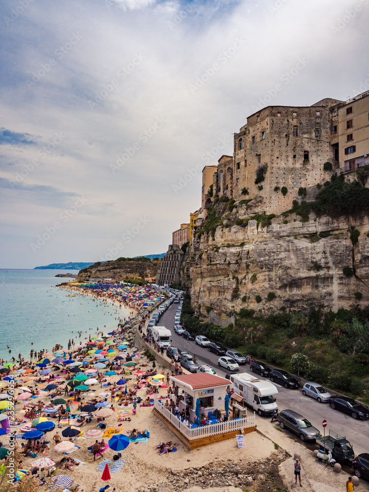 Panorama of Tropea, Italy and the crowded beach of bathers.