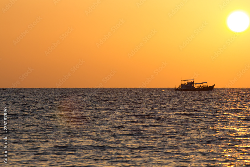 Boot fährt auf dem Meer in Thailand dem Sonnenuntergang entgegen