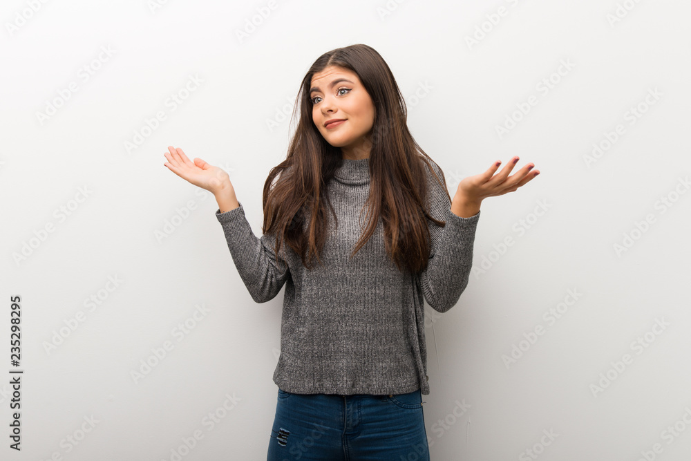 Teenager girl on isolated white backgorund making unimportant gesture while lifting the shoulders Teenager girl on isolated white backgorund making unimportant gesture while lifting the shoulders
