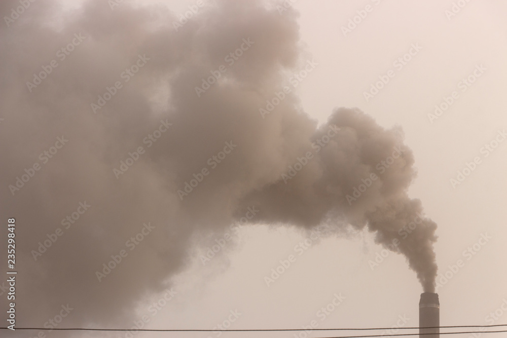 The pipe of the plant emits harmful substances into the atmosphere. Close-up on a sky background The pipe of the plant emits harmful substances into the atmosphere. Close-up on a sky background
