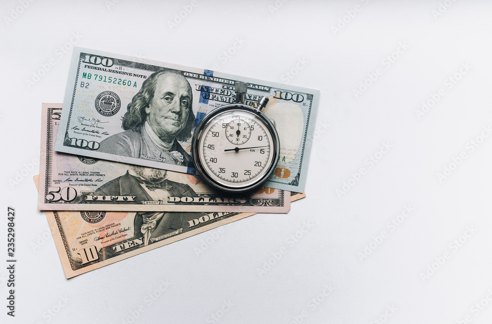 Stopwatch and dollars. Time is money concept. Banknotes and coins. Money loan. White background. Stopwatch and dollars. Time is money concept. Banknotes and coins. Money loan. White background.