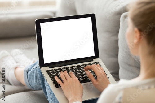 Close up of female sit on cozy sofa writing email on laptop, girl freelancer working at computer from home, focused student studying un bed, woman texting with friend or writing message to colleague