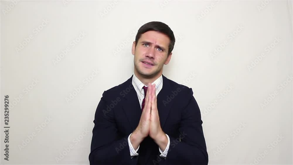 Young handsome businessman praying speaks please, asking God for help in business.Portrait on a white background. Young handsome businessman praying speaks please, asking God for help in business.Portrait on a white background.