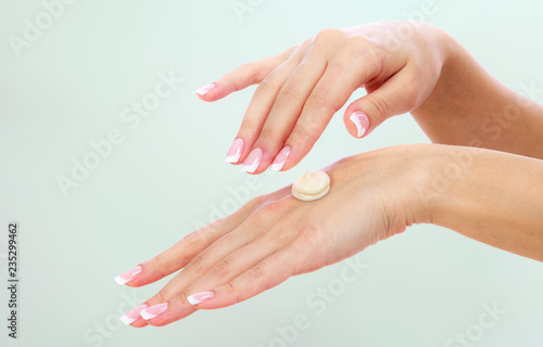 Well-groomed female hands with a cream on one of them. Skin care concept