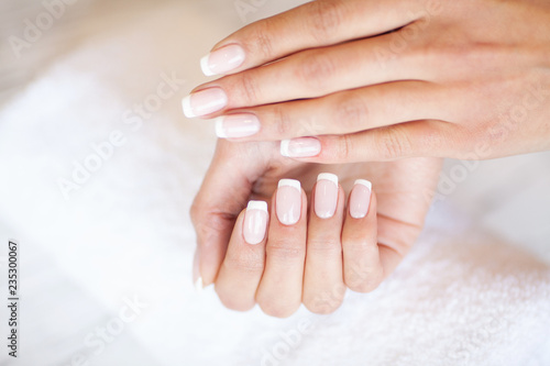 Woman Hand Care. Closeup Of Beautiful Female Hands Having Spa Manicure At Beauty Salon. Beautician Filing Clients Healthy Natural Nails With Nail File. Nail Treatment