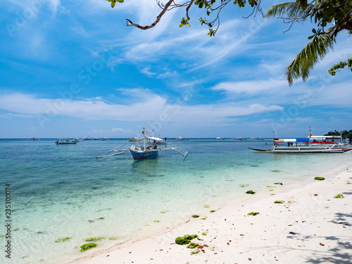 Bohol, Philippines - November, 2018: Swimmers and boats on Alona Beach in Panglao Island, Bohol. Aloha beach is the most visited touristic spot in Bohol photo