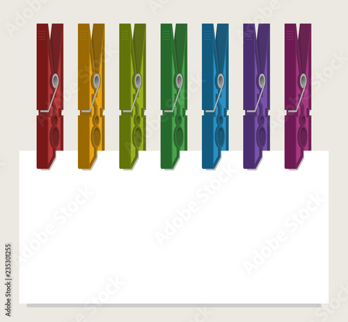 Colorful clothes-pegs holding piece of paper