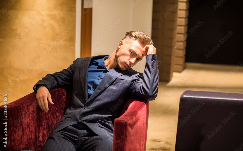 Handsome elegant man in hotel or night club lounge, wearing shirt, looking at camera Handsome elegant man in hotel or night club lounge, wearing shirt, looking at camera