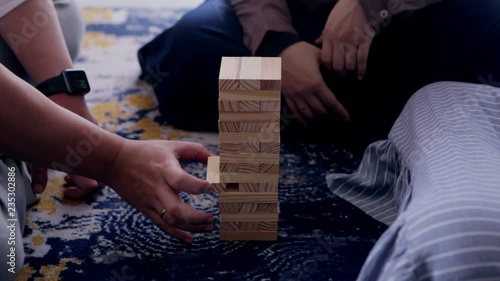 Man and women playing jenga at bedroom. Friends having fun playing jenga at bedroom.
