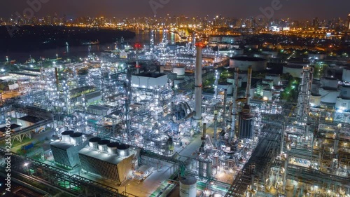Wallpaper Mural Aerial drone hyper lapse over oil refinery factory at night with city and river in background. Shot by 4K high resolution drone. Torontodigital.ca