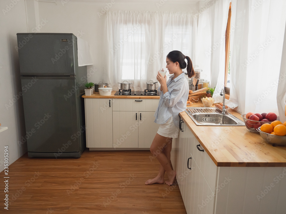 asian woman drink milk in the kitchen asian woman drink milk in the kitchen