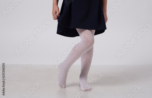 legs of a little girl in white tights