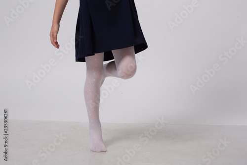 girl in white pantyhose walks on the white floor