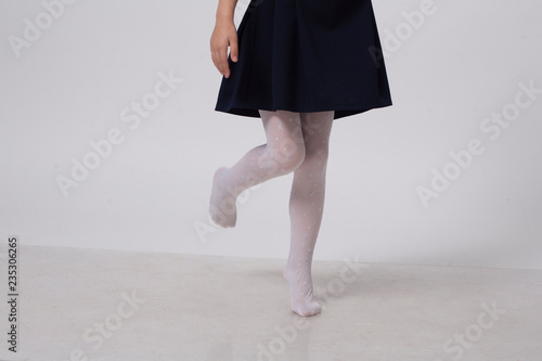 girl in white pantyhose walks on the white floor