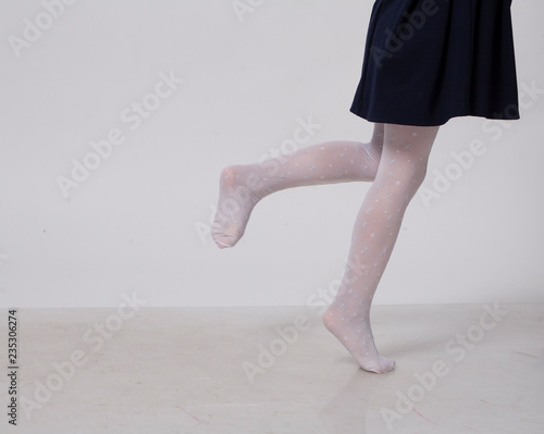 girl in white pantyhose walks on the white floor