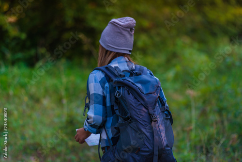 Young woman walking alone in the woods. Hiking concept in the mountain in summer