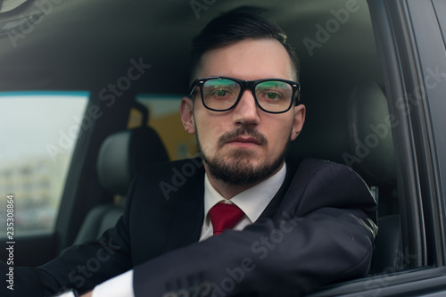 Serious businessman driving luxury car. © pavel_shishkin