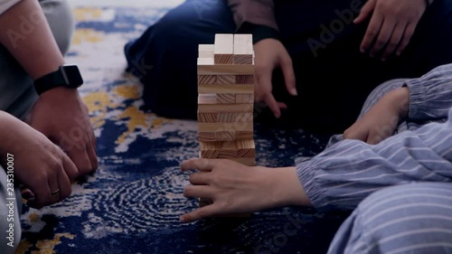 Man and women playing jenga at bedroom. Friends having fun playing jenga at bedroom.