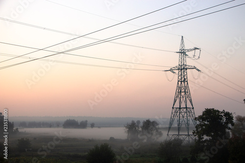 High voltage electricity transfer lines and pylon in a fog