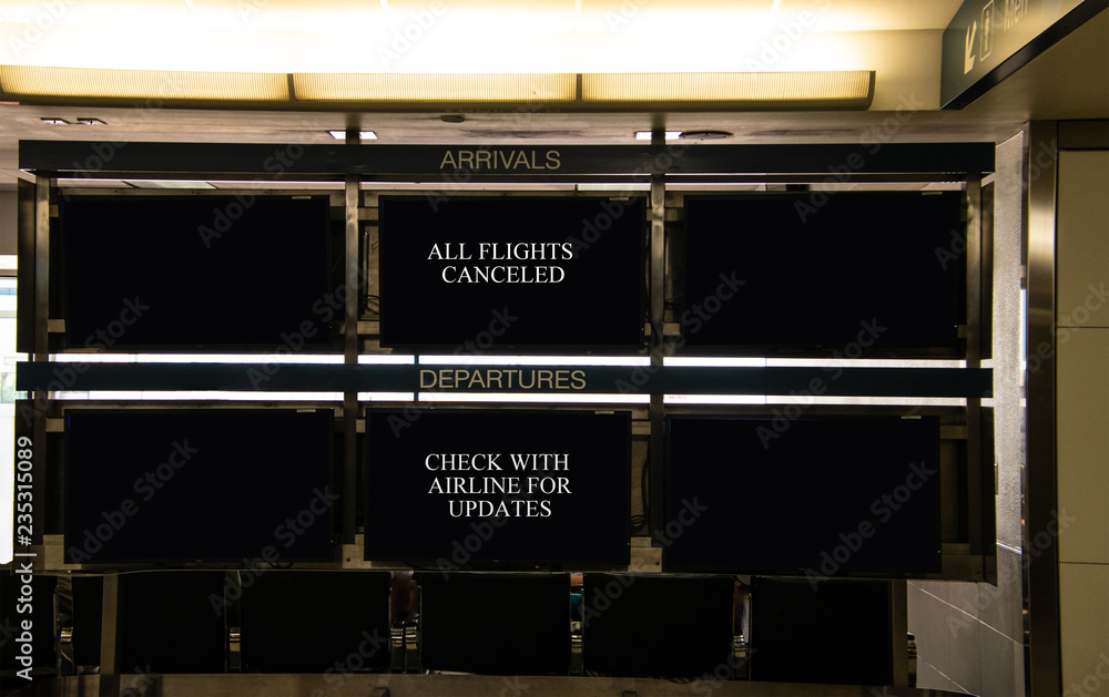 Obraz premium Airport arrivals and departure signs that indicate that all flights are canceled and that travelers should check with airlines