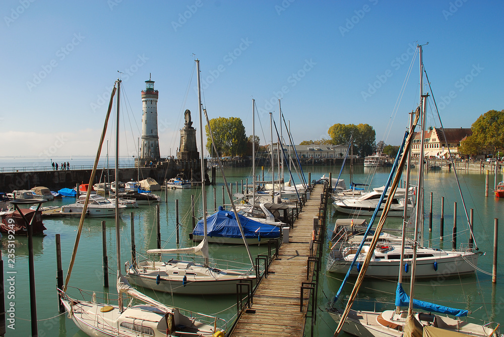 Fototapeta premium Harbour entrance of Lindau, Lake Constance (German: Bodensee) with the new lighthouse and the Bavarian Lion