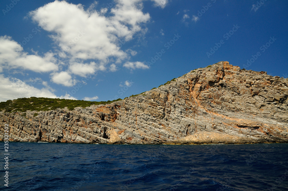 A Beautiful Sun Lit Cliff Surrounded by Dark Blue Sea