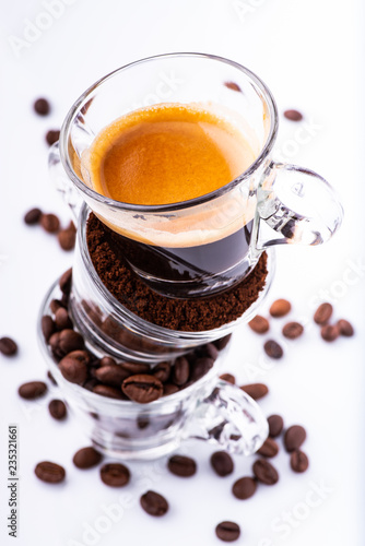 glass cups, in sequence vertically, with coffee beans, ground, and creamy drink. still life photo