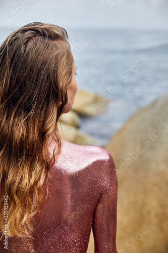 Woman's Back Covered By Golden Glitter