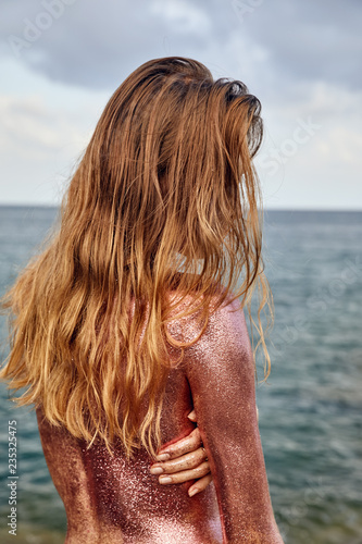 Woman's Back Covered By Golden Glitter
