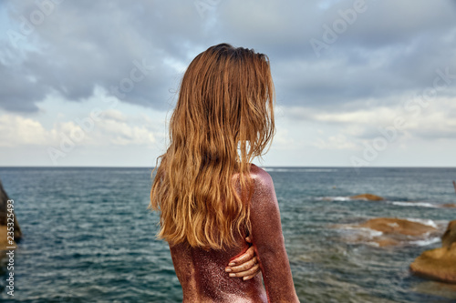 Woman's Back Covered By Golden Glitter