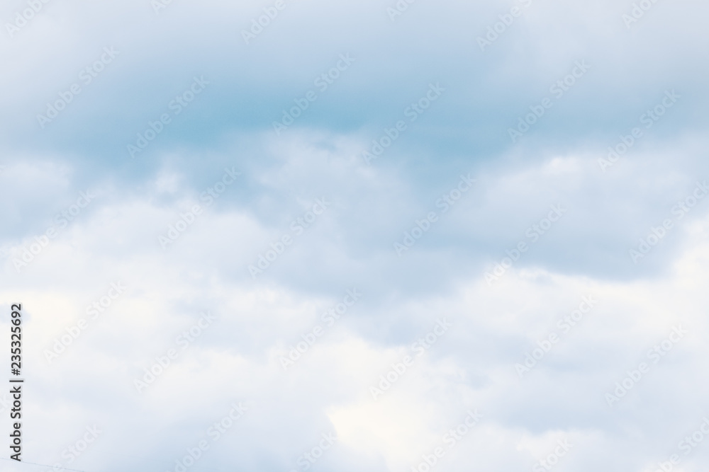 Fluffy dreamy clouds in light blue sky. For background and wallpaper