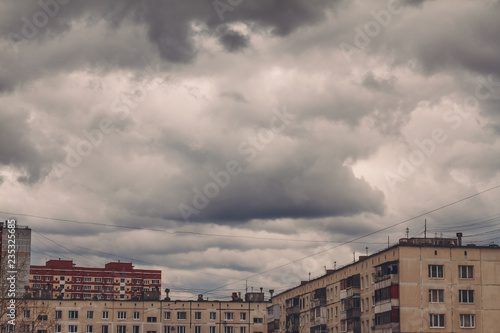 Dark, gloomy overcast sky over buildings in city during thunderstorm