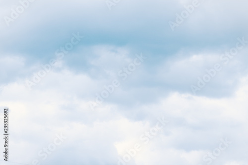 Fluffy dreamy clouds in light blue sky. For background and wallpaper