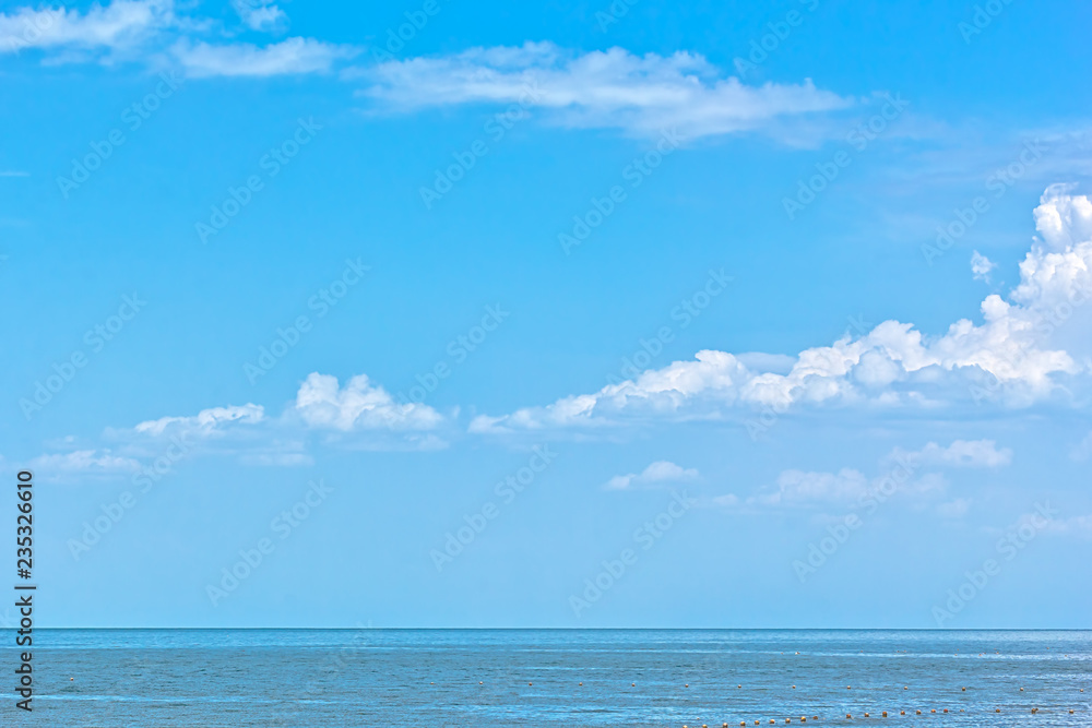 White fluffy clouds over the blue sea